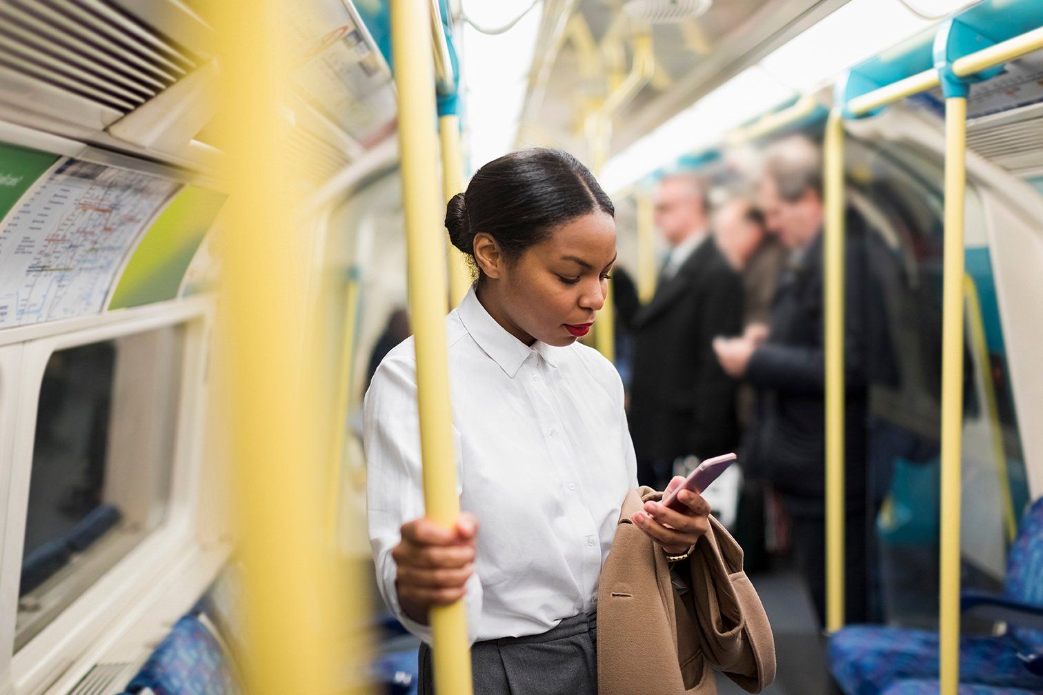 woman holding pole on train